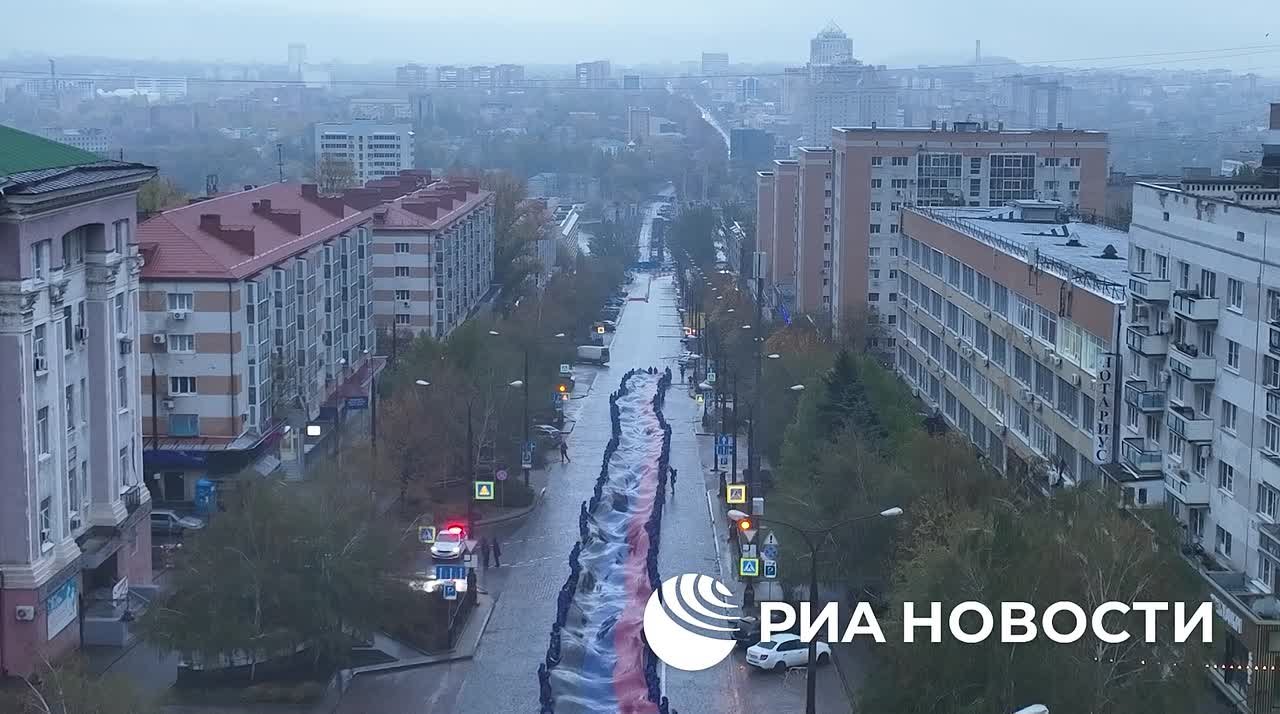 Молодежь Донецка развернула в центре города 200-метровый флаг ДНР ко Дню республиканского символа, передает корреспондент РИА Новости